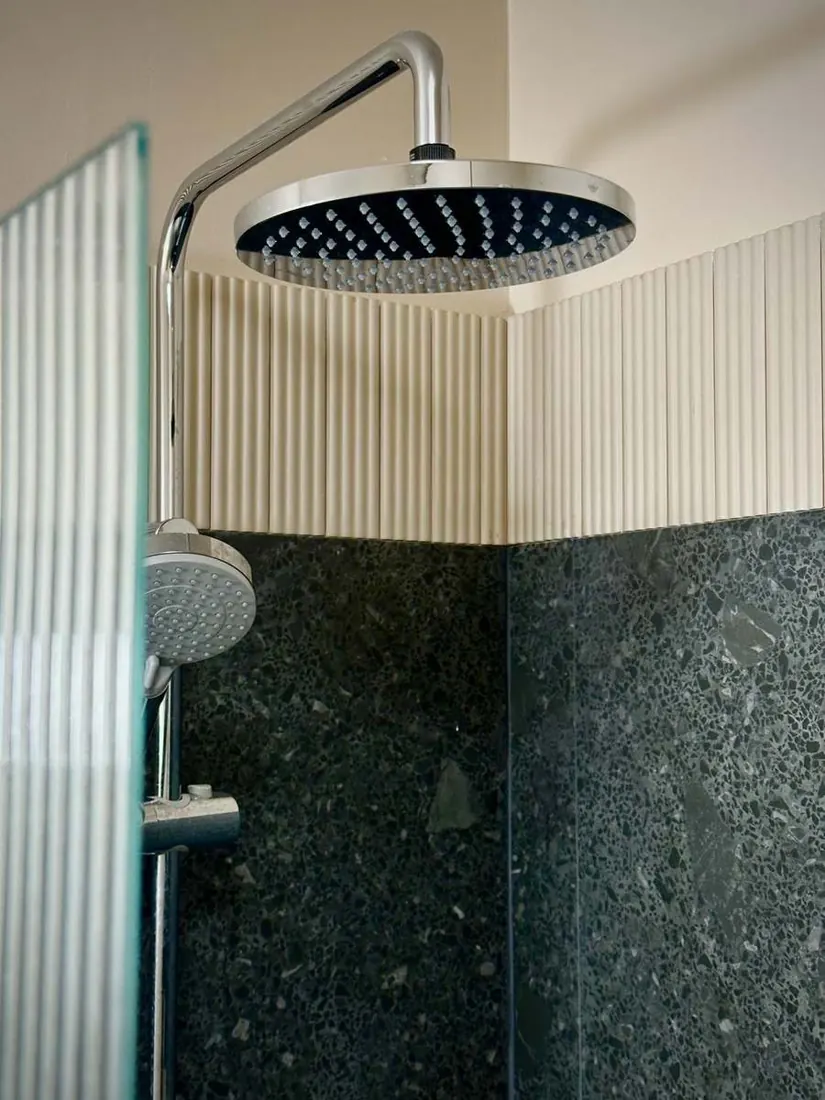 Douche à l’italienne, pierre sombre et faïence cannelée